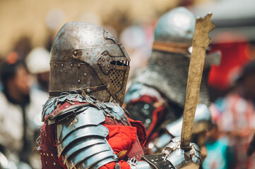 Pitch battle of medieval knights, using metal armor, axes, swords and shields to defend themselves.