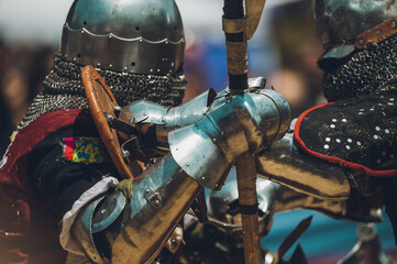 Pitch battle of medieval knights, using metal armor, axes, swords and shields to defend themselves.