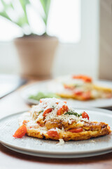 Homemade omelet with mozzarella cheese, parmesan and cherry tomatoes.