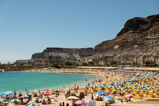 Beach with many umbrellas near Rocky Mountain