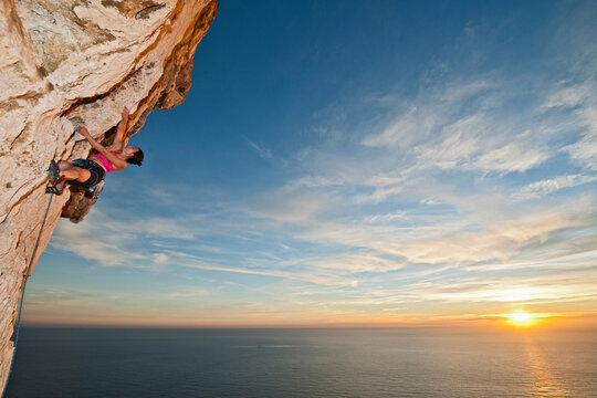woman climbing rock face at the French Cote d'Azur