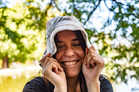 Young playful woman pulling down her hat