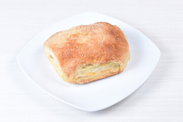 Puff pastry cake with arequipe and cheese, on a wooden background