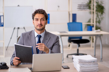 Young male employee sitting at workplace