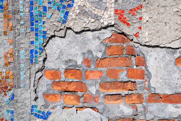 Ruined brick wall made of small mosaics. Finishing the surface of the building with pieces of stone. Intarsia.