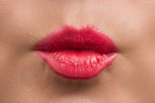 kiss of female lips with red lipstick close-up