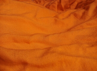 orange cotton fabric texture with wrinkled and wavy surface. soft and fluffy material for the fabric background