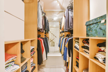 Fototapeta na wymiar Wardrobe with good brightness, full of clothes and shelf