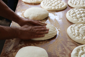selective focus: Turkey's traditional ramadan pita is shaped by hand before cooking in a wood fire