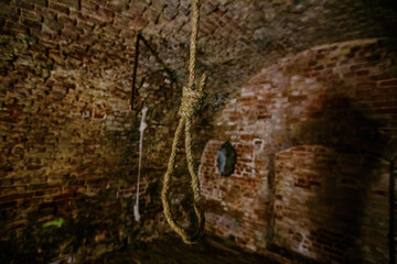 Hanging noose of rope in dark creepy abandoned cellar - obrazy, fototapety, plakaty