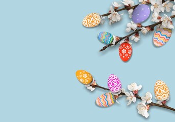 Happy Easter concept! Colorful Easter chocolate eggs with blossoms flat lay on blue background.