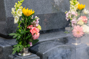 祖先を供養するための花と線香の煙