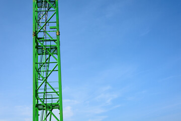 Fototapeta na wymiar Green crane poles and ladder in the sky