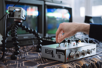 A hand manipulating a custom DIY circuit bent interface to glitch analog VHS signals