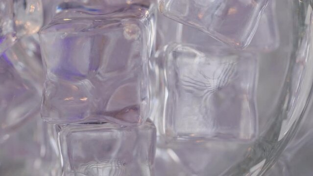 Close-up from above, dry ice cubes rotate and are filled with a carbonated drink