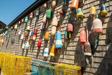 Different floats and buoys on the wall of a wooden house. Sea fishing tackle. USA. Maine.