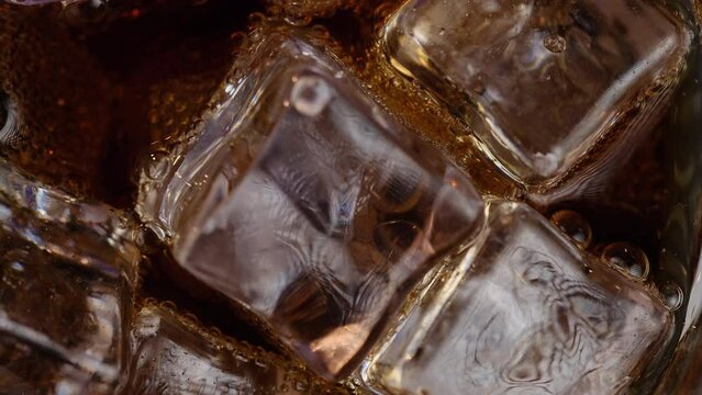 Close-up top view of ice spinning with a carbonated drink