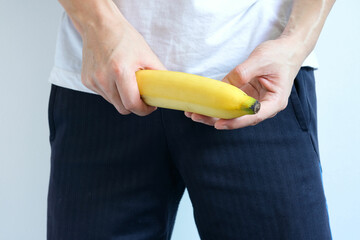A young man holding a banana symbolizes the penis of a man in an erect state.