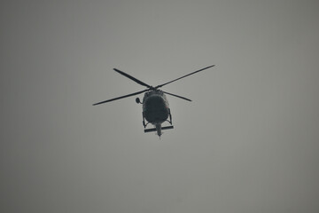 Fototapeta na wymiar view from below of a military helicopter with a gray sky in the background.