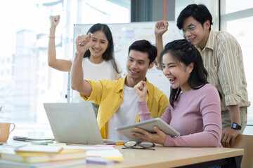 Excited young businesspeople celebrating start up business victory or success in office. Teamwork, collaboration concept.