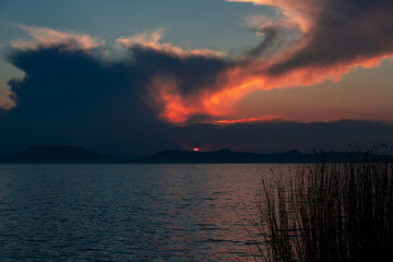 landscape with a sunset with colorful clouds on the lake