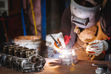 The man in the face mask is welded by argon welding. Welder industrial worker welding with argon...