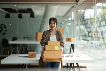 Starting small businesses SME owners female entrepreneurs holding stack of box to review orders...