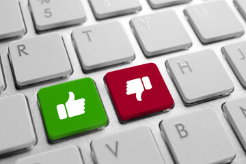 Buttons with symbols THUMB-UP and THUMB-down on computer keyboard, closeup. Online voting concept