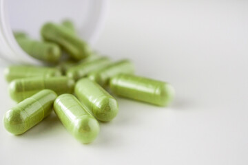 Herbal medicine capsules with bottle on white background