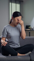 Fototapeta premium Asian woman was sick with eyes pain sitting on sofa at home.