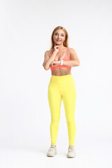 Female runner checking pulse on light background