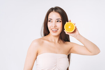 Beauty funny portrait of happy smiling asian woman with dark long hair with oranges in hands on white background isolated