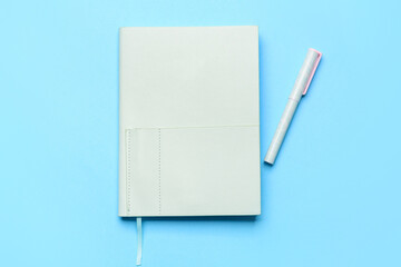 Notebook and pen on blue background