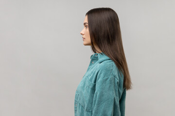 Side view of portrait of strict bossy woman looking ahead, feels confident focused self-assured, expressing seriousness, wearing casual style jacket. Indoor studio shot isolated on gray background.