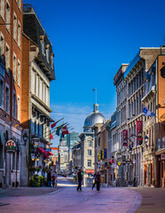 Saint Paul street in old town Montreal on a clear fall day, with the dome of Marché Bonsecours in the background