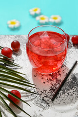 Glass of fresh grape soda on edge of swimming pool, closeup