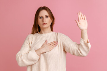 Portrait of honest blond woman standing with promise hand sign, gesturing palm up, giving promise,...