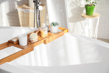 Bathtub tray with body massage brush, candle and cosmetic products