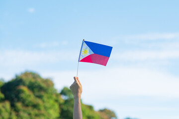 hand holding Philippines flag on nature background. 12th June of Independence day and happy celebration concepts