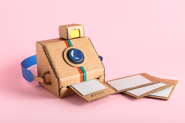 Cardboard photo camera with pictures on pink background
