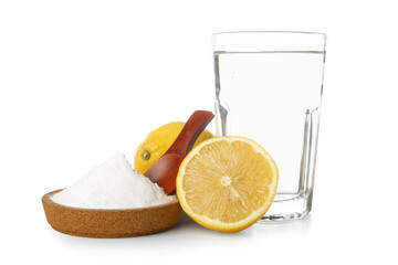Glass of water, ripe lemons and bowl with soda on white background