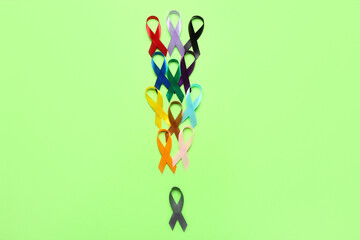 Awareness ribbons on green background. World Cancer Day concept