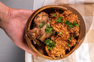 Bowl of east African Jollof Rice garnished with pieces of roasted chicken