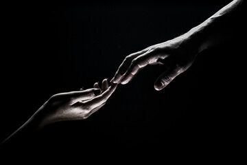 Hands gesturing on black background. Giving a helping hand. Support and help, salvation. Hands of two people at the time of rescue. Romantic touch with fingers, love. Hand creation of adam. - obrazy, fototapety, plakaty