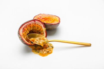 Delicious cut passion fruit with spoon on white background