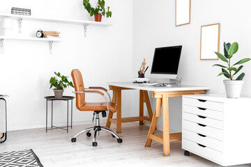 Workplace with modern computer near white wall