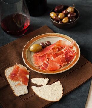 Spanish Jamon Ibérico with crackers, olives and red wine