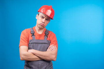 Bored male builder in uniform with crossed arms