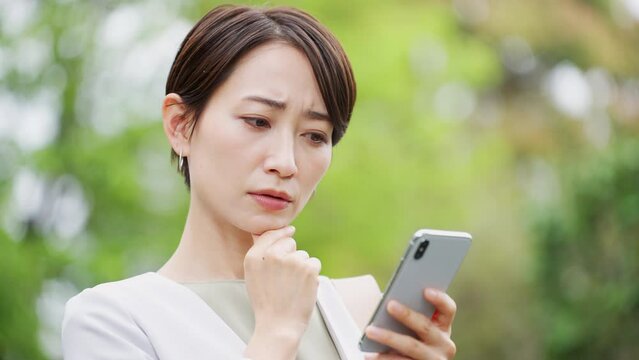 スマートフォンを操作する若いビジネスウーマン