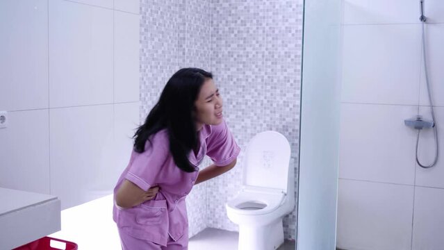 Young woman suffering stomach ache in bathroom